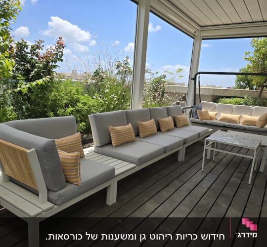 כריות פסים צהובות על ספות אפורות במרפסת